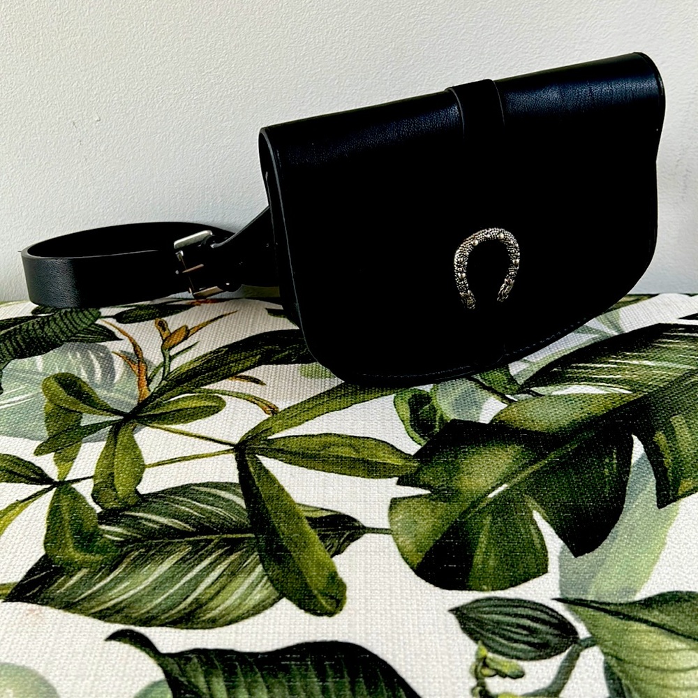 Stylish belt bag with silver metal horse shoe logo in the front.